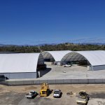 3 container domes with cars parked in front