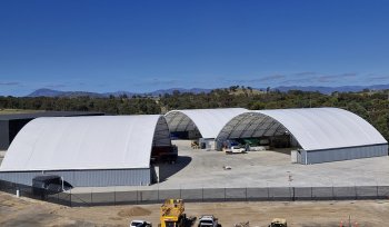 3 container domes with cars parked in front
