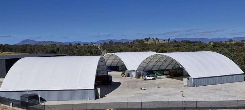 3 container domes with cars parked in front