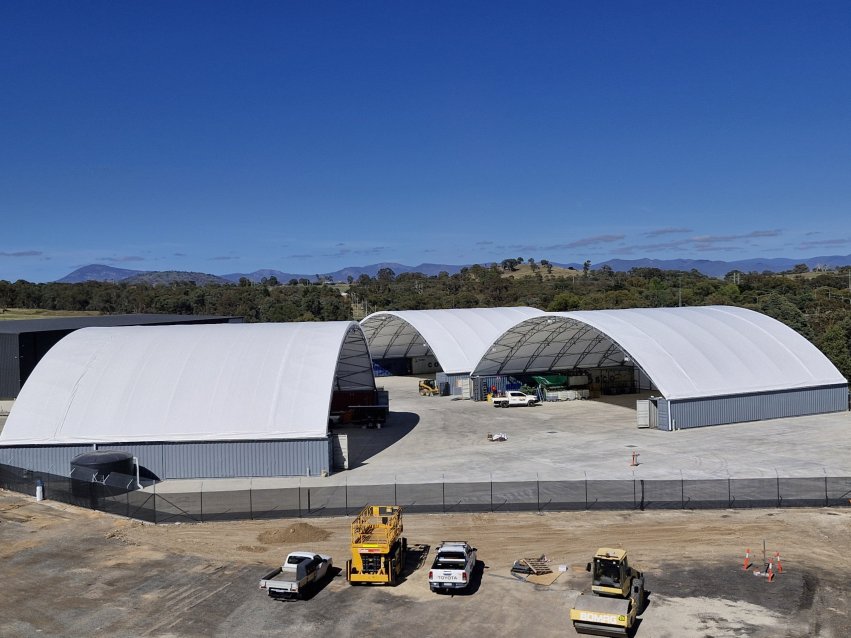 3 container domes with cars parked in front